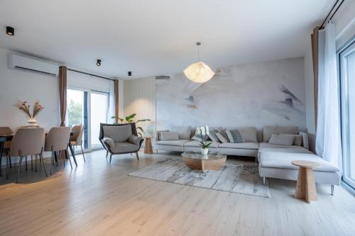 una sala de estar con un sofá y una mesa en Rooftop Holiday House, en Brodarica