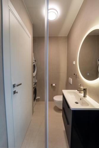 a bathroom with a sink and a mirror and a toilet at Rooftop Holiday House in Brodarica