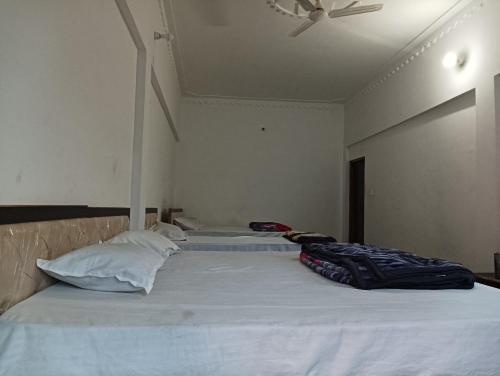 two beds in a bedroom with a ceiling fan at Vasudhara Hotel & Restaurant in Pīpalkoti