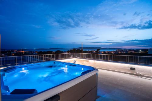 Un jacuzzi en lo alto de un balcón por la noche. en Rooftop Holiday House, en Brodarica