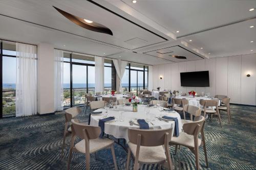a conference room with tables and chairs and a screen at Hotel La Jolla, Curio Collection by Hilton in San Diego