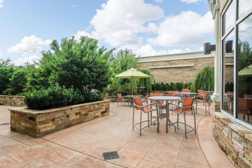 a patio with a table and chairs and an umbrella at Hilton Garden Inn Dalton in Dalton