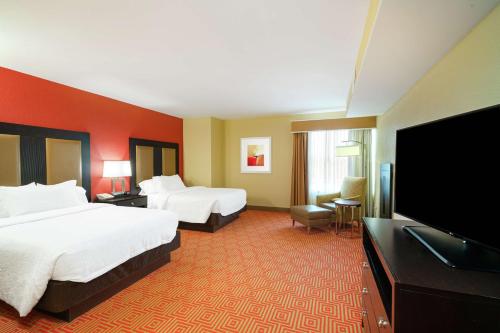 a hotel room with two beds and a flat screen tv at Hilton Garden Inn Dalton in Dalton