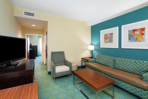 a living room with a couch and a flat screen tv at Hilton Garden Inn Dalton in Dalton