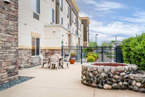 a patio with a table and chairs in front of a building at Comfort Suites Redding - Shasta Lake in Redding