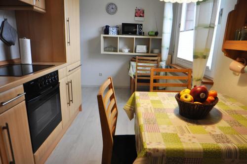 a kitchen with a table with a bowl of fruit on it at Ferienwohnung Mona, 65314 in Moormerland