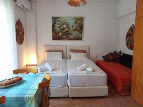 a hotel room with two beds and a couch at Palm mountain view &no sea view in Possidi