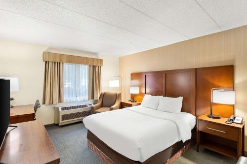 a hotel room with a large bed and a desk at Comfort Inn White River Junction in White River Junction