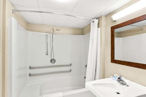 a bathroom with a white tub and a sink at Comfort Inn White River Junction in White River Junction