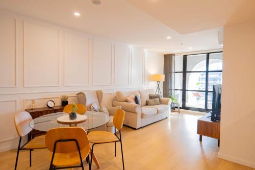 a living room with a couch and a table and chairs at 2 Bedroom 2 bath 1 Car on Lonsdale Street in Canberra