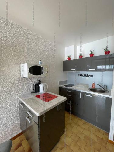 une petite cuisine avec un comptoir et un micro-ondes dans l'établissement Idéal couple avec vue sur le PORT DE GRUISSAN 4CHE24, à Gruissan