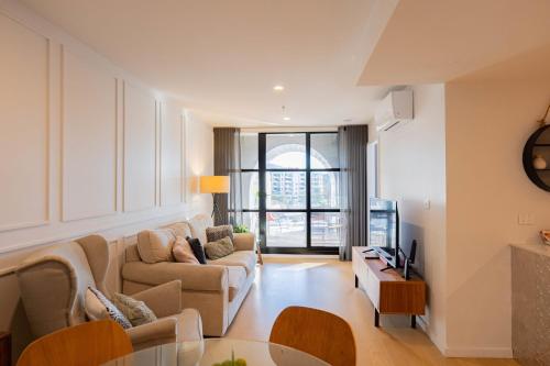 a living room with a couch and a table at 2 Bedroom 2 bath 1 Car on Lonsdale Street in Canberra