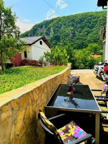 a table and chairs in front of a stone wall at Apartman EDEN in Jajce