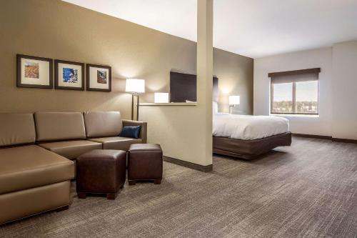 a hotel room with a bed and a couch at Comfort Suites Brunswick - Cleveland Southwest in Brunswick