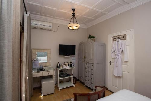 a room with a bedroom with a desk and a dresser at Oleander Guest House in Kimberley