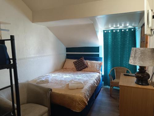 a small bedroom with a bed and a chair at Jewel Of The Sea Hotel in Blackpool