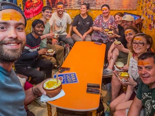 a group of people sitting around a table eating food at Karma Hostel in Khajurāho