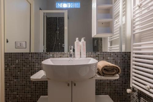 a bathroom with a sink and a mirror at Barbaroux Apartments by Wonderful Italy in Turin