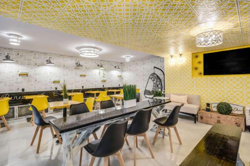 a restaurant with yellow chairs and tables and yellow walls at Clarion Pointe Tallahassee-State Capitol in Tallahassee
