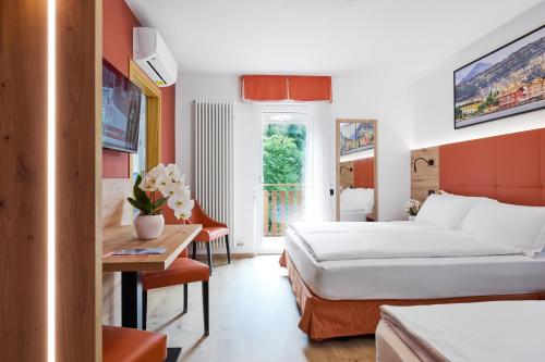 a hotel room with two beds and a table at Residence Hotel Miralago in Pergine Valsugana