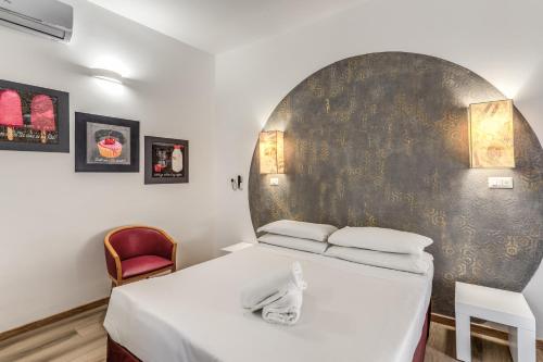 a bedroom with a bed and a red chair at Hotel Santa Prassede in Rome