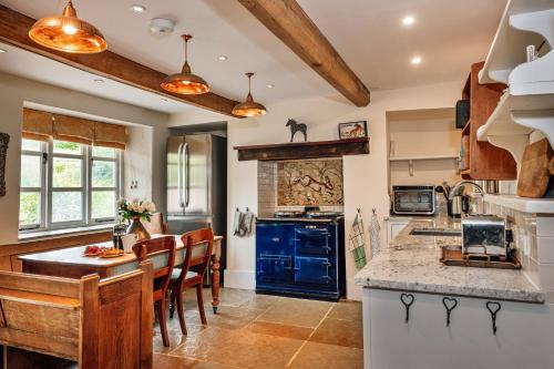 a kitchen with a counter and a table and chairs at Finest Retreats - Beili Glas Cottage in Penrhôs