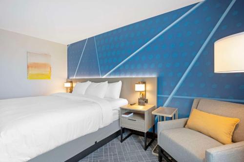 a hotel room with a bed and a chair at Comfort Inn & Suites US-60 in Mountain Grove