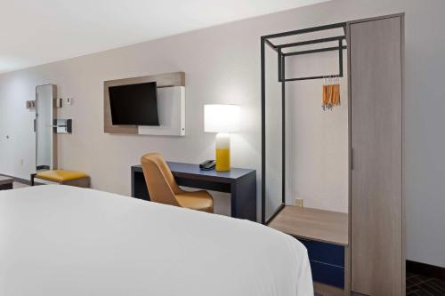 a hotel room with a bed and a desk and a tv at Comfort Inn & Suites US-60 in Mountain Grove