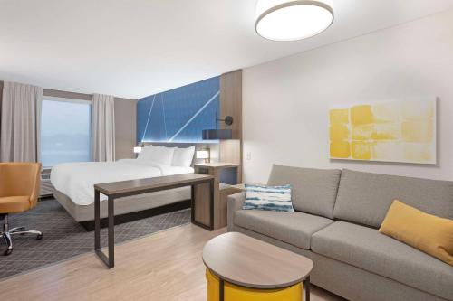a hotel room with a bed and a couch at Comfort Inn & Suites US-60 in Mountain Grove