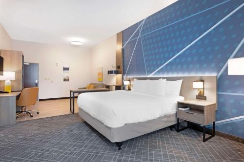 a hotel room with a large bed and a desk at Comfort Inn & Suites US-60 in Mountain Grove