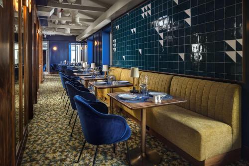uma fila de mesas num restaurante com cadeiras azuis em DUO Hotel Lisbon, Curio Collection by Hilton em Lisboa
