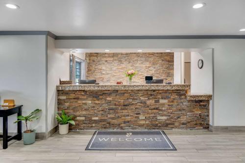 a lobby with a welcome mat in front of a brick wall at Country Inn & Suites by Radisson, Grand Rapids Airport, MI in Grand Rapids