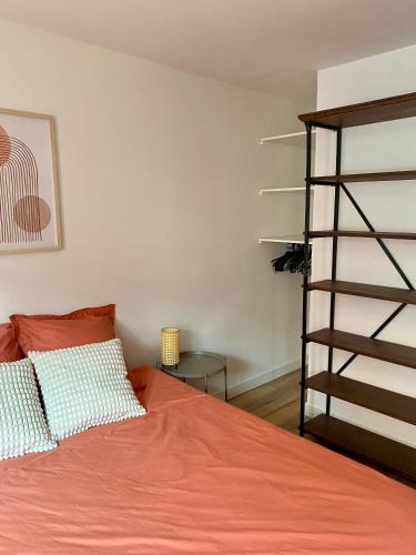 une chambre avec un lit et une étagère dans l'établissement Chez Marcel - Maison agréable, à Dunkerque