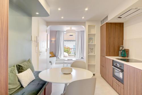 Il comprend une petite cuisine avec une table blanche et une petite chambre. dans l'établissement Alma Florian apartment 4 people with terrace, à Cannes