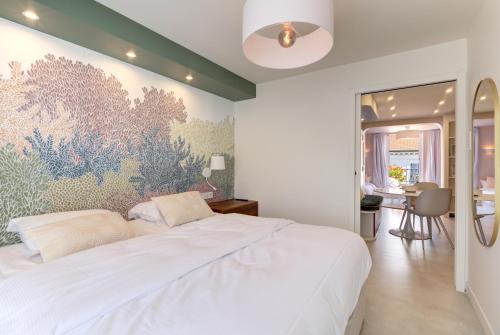 - une chambre avec un grand lit blanc orné d'une peinture murale dans l'établissement Alma Florian apartment 4 people with terrace, à Cannes