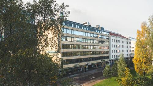 a large white building with windows on a street at GreenStar Hotel Oulu in Oulu