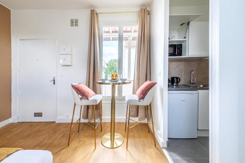 - une petite cuisine avec une table et deux tabourets dans l'établissement Studio Banlieue Parisienne - Issy-les-Moulineaux, à Issy-les-Moulineaux