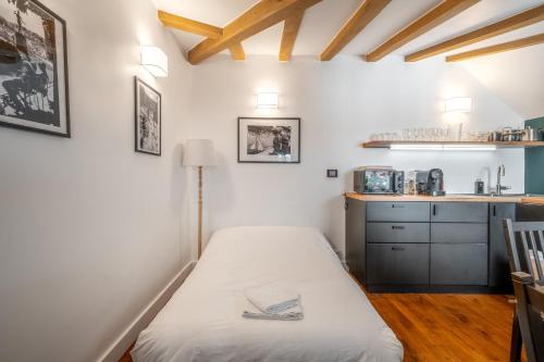 ein kleines Zimmer mit einem Bett und einer Küche in der Unterkunft My Little House in Paris * Hypercentre * Climatisé in Paris