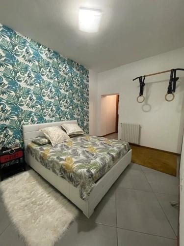 a bedroom with a bed and a blue and white wall at La Casa di Chicco in Venegono Superiore