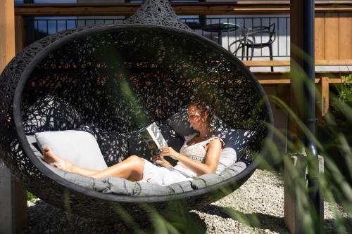 a woman laying in a hammock reading a book at KaiserMoments in Going