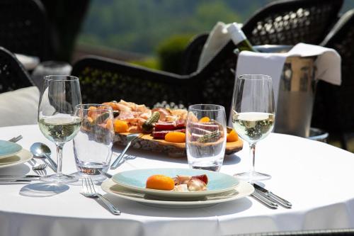 a table with a plate of food and wine glasses at Hotel du Léman - Jongny in Vevey