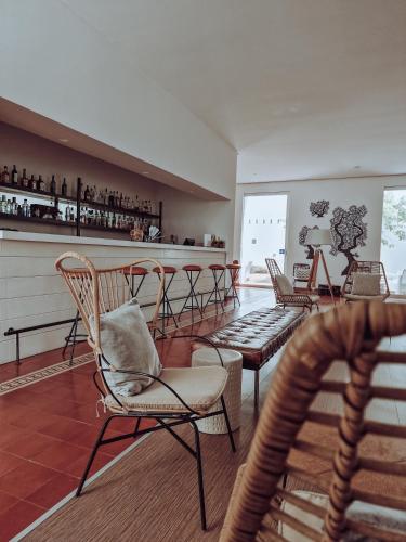 a room with chairs and a bar with a counter at The Lince Ecorkhotel Évora in Évora