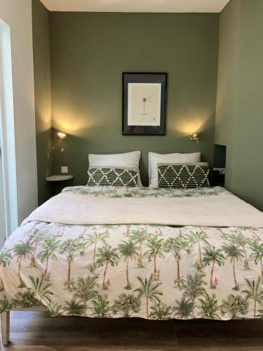 a bedroom with a large bed with palm trees on it at Antonia beach house in Scheveningen