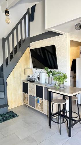 une salle à manger avec une table et une télévision dans l'établissement Pavillon climatisé avec extérieur et piscine collective - 4PAV87, à Saint Pierre La Mer