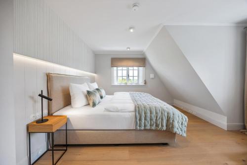 une chambre blanche avec un lit et une fenêtre dans l'établissement Gardenlodge 2, à List auf Sylt