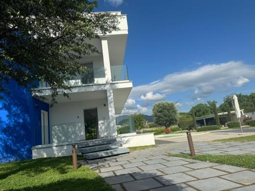 a white building with a pathway in front of it at Ohahsi in Nola