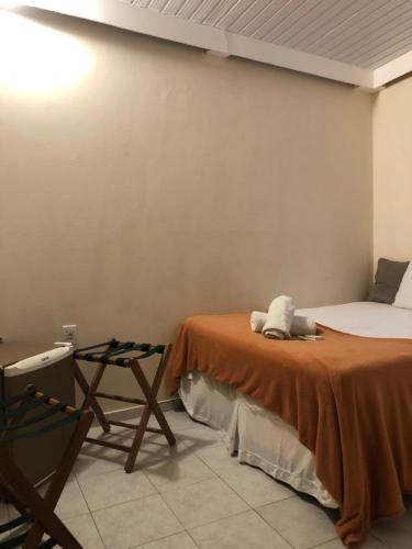 a room with a bed and a chair in it at Morro de São Paulo Hospedagens in Morro de São Paulo