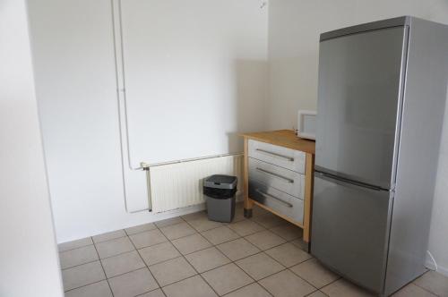 a kitchen with a stainless steel refrigerator and a counter at Kustverhuur, Oude manege, Nieuwvliet 14-16 in Nieuwvliet