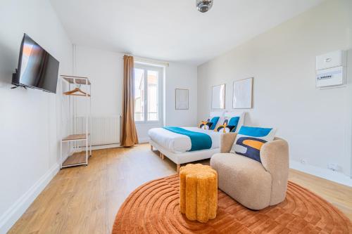 een slaapkamer met een bed, een bank en een stoel bij Magnifique studio proche de la capitale in Issy-les-Moulineaux