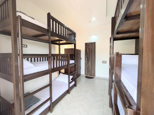 a room with three bunk beds in a room at Kanasu Serenity in Gokarna